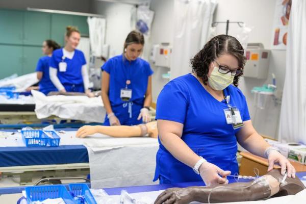 Nursing students practice working with IVs inside the UK College of Nursing's Simulation Center. Photo by Shaun Ring.