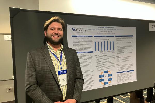 A man standing in front of a research poster. 