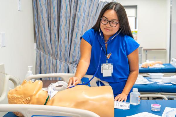 Student using stethoscope on simulation manequin.