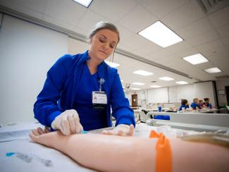 Photo of nursing student using dummy in clinical course