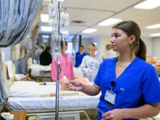 Candid photo of nursing student partaking in nursing simulation. 