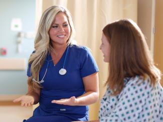 Nurse speaking to patient, smiling
