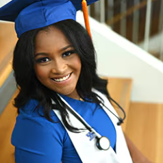 Photo of Jordan Brown smiling wearing a graduation cap and gown. She also has a stethoscope around your neck. 