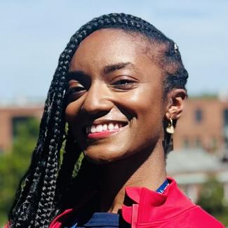 Headshot photo of Tatiyana Dean wearing red outside.