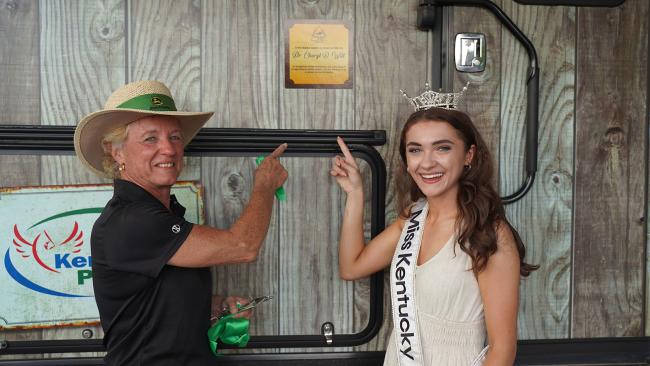 Dr. Cheryl Witt and Miss Kentucky Ariana Rodriguez point to the dedication plaque of the Raising Hope Mobile Agriculture Safety and Health (MASH) barn.