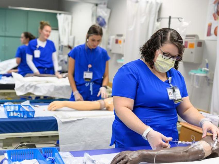Nursing students practice working with IVs inside the UK College of Nursing's Simulation Center. Photo by Shaun Ring.