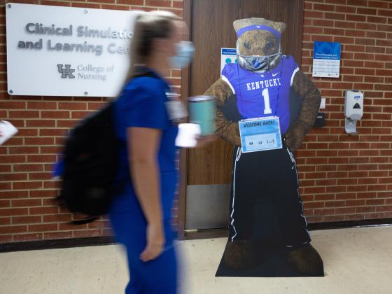 Student walking past the Clinical Simulation & Learning Center in the College of Nursing building. 