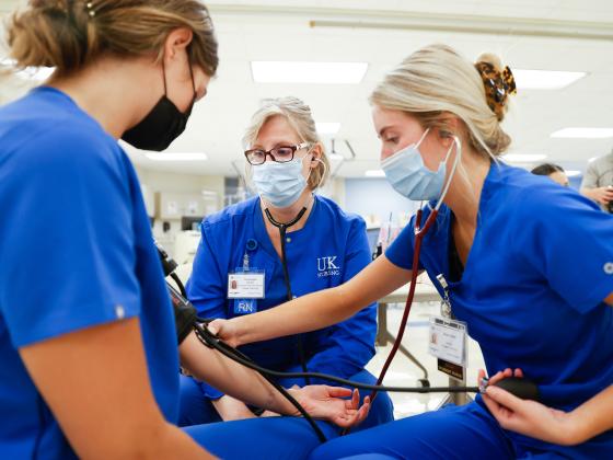 Nursing students learning how to check blood pressure.