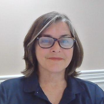 A headshot photo of a woman with glasses.