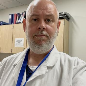 Photo of James Davis. He is wearing a medical whitecoat. 