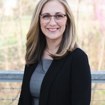 A headshot photo of Kaitlin Key. She is wearing glasses and standing outside. 