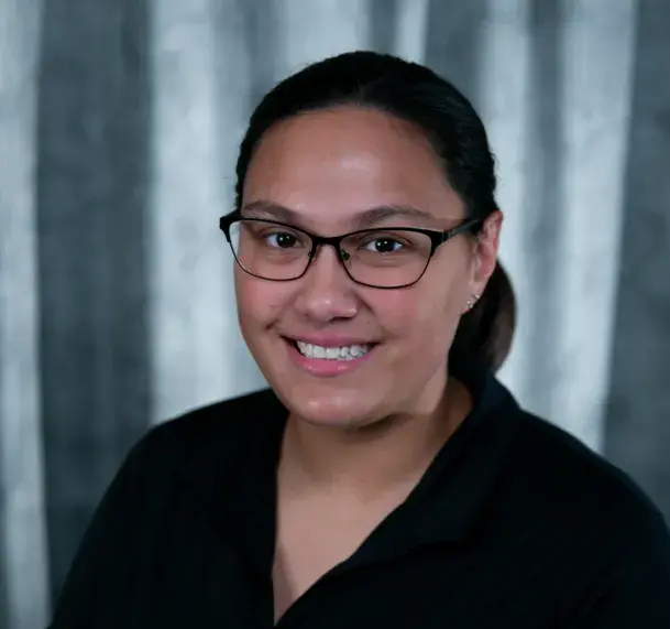 A headshot photo of a woman wearing glasses.