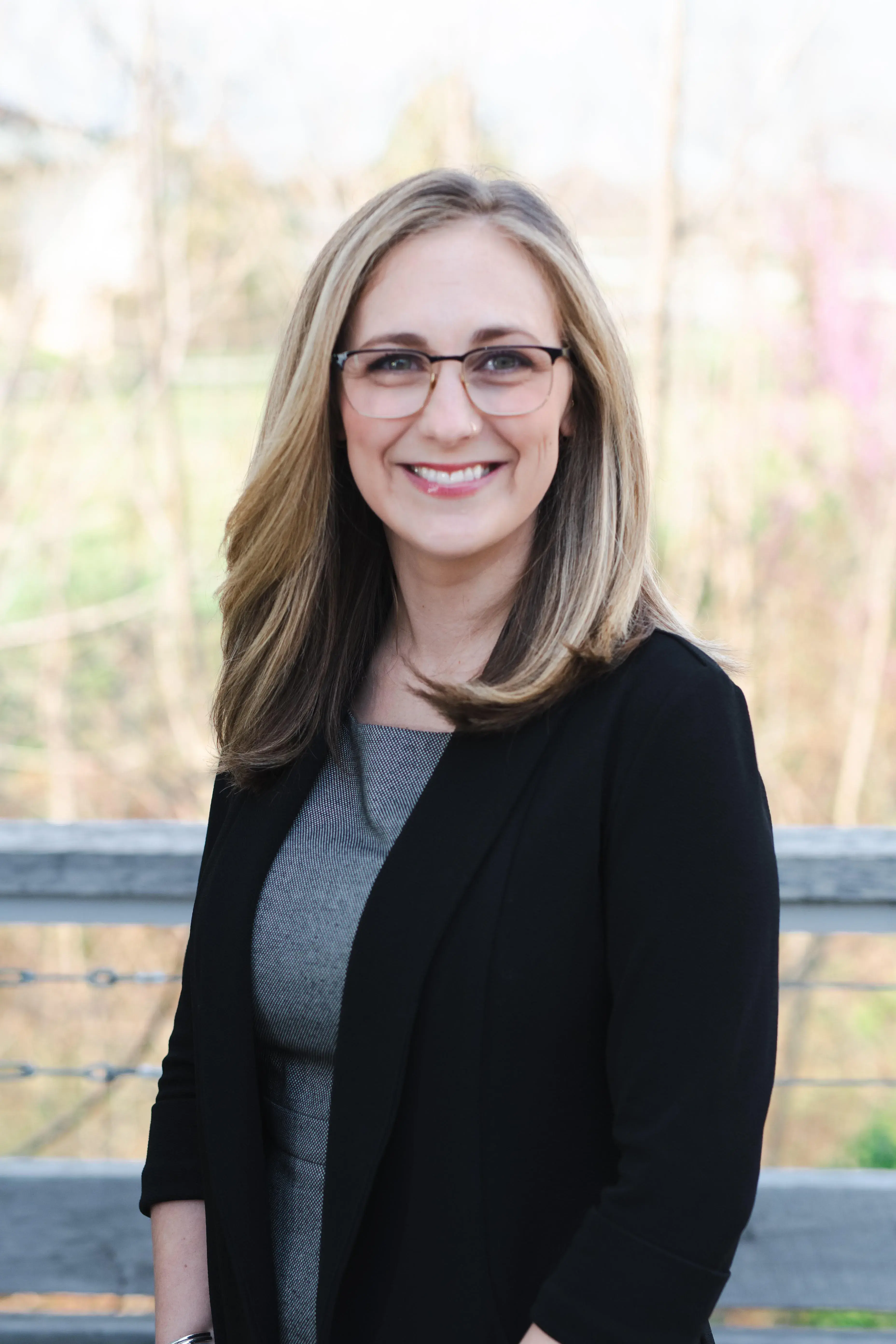 A headshot photo of Kaitlin Key. She is wearing glasses and standing outside. 